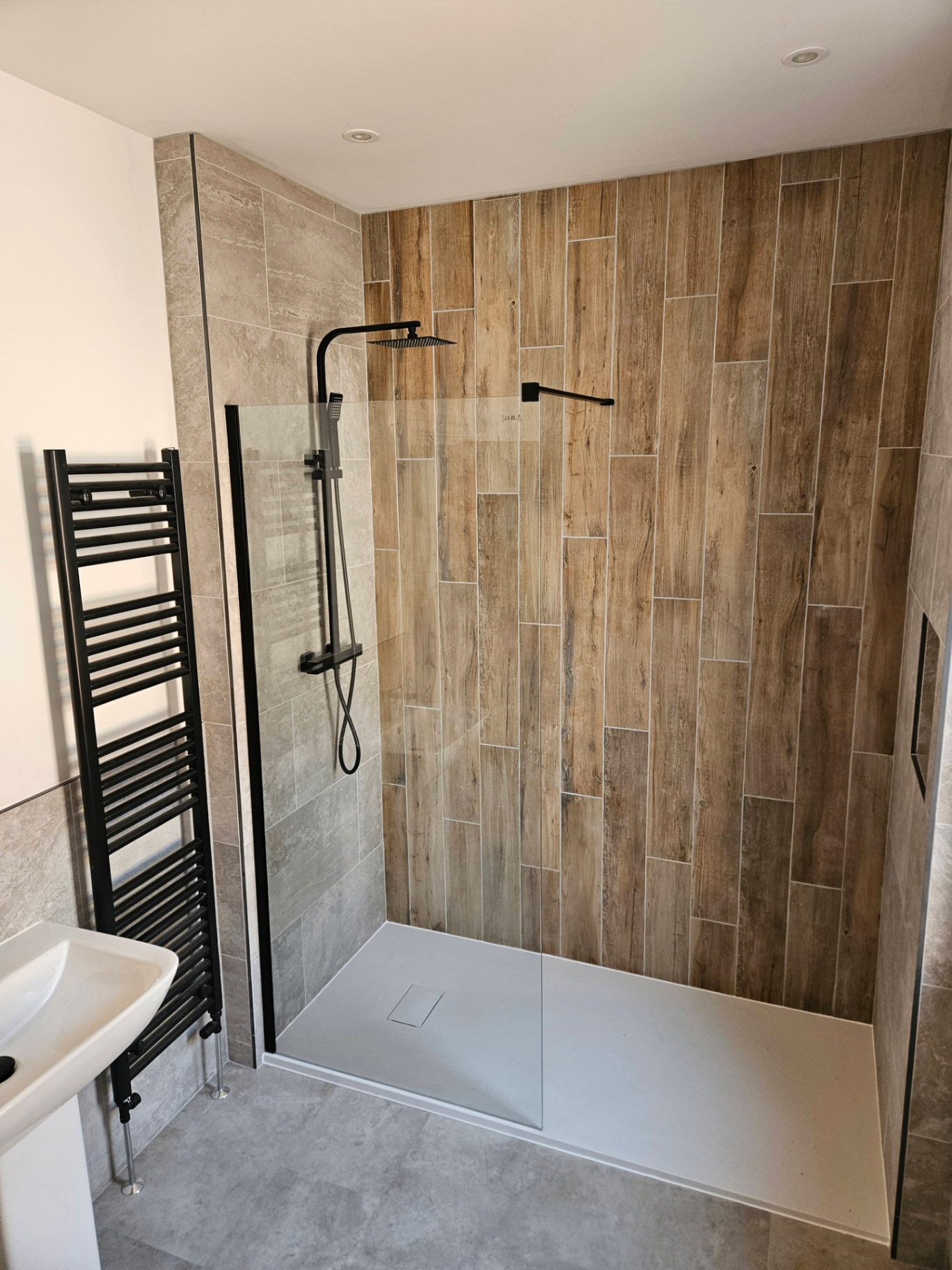 Walk-in shower with timber-effect tiles and matt black fittings